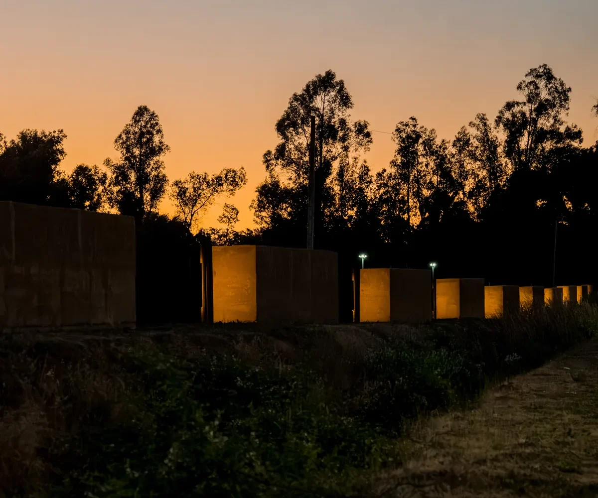 Cierres perimetrales de hormigón iluminados al atardecer