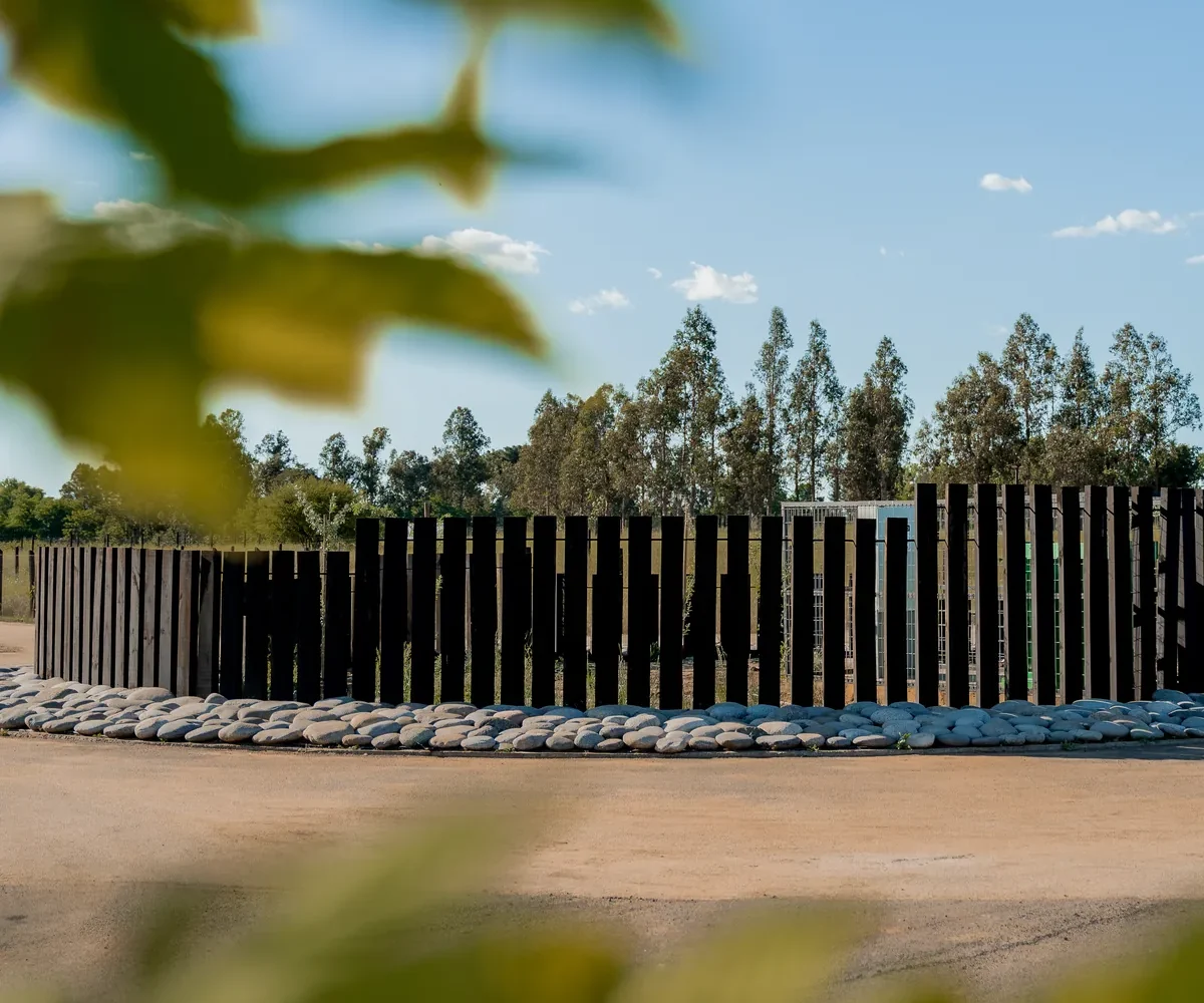 Cierre de durmientes de madera con jardín de piedras de río