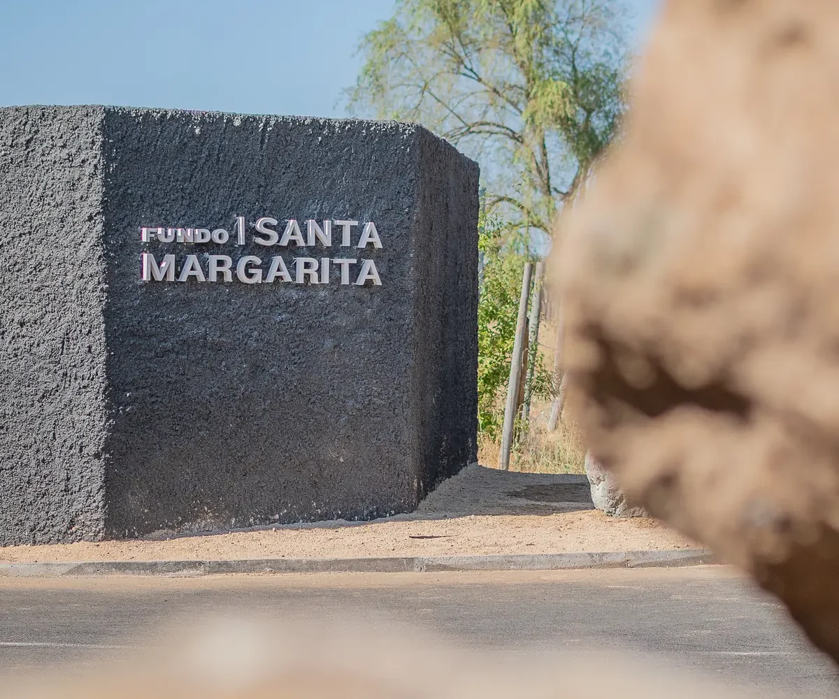 Muro de acceso de Fundo Santa Margarita con el nombre del proyecto en letras metálicas
